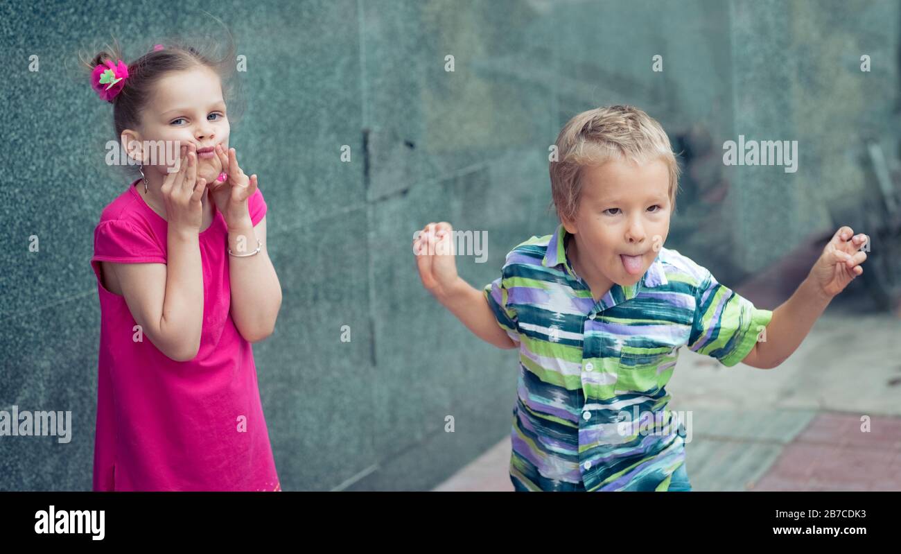 Ragazzo e ragazza che fa divertenti facce all'aperto Foto Stock