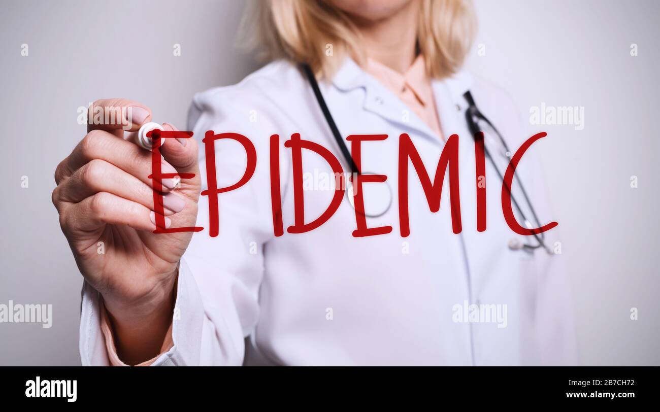 Medico femminile che scrive l'EPIDEMIA di parola sullo schermo virtuale contro sfondo bianco Foto Stock