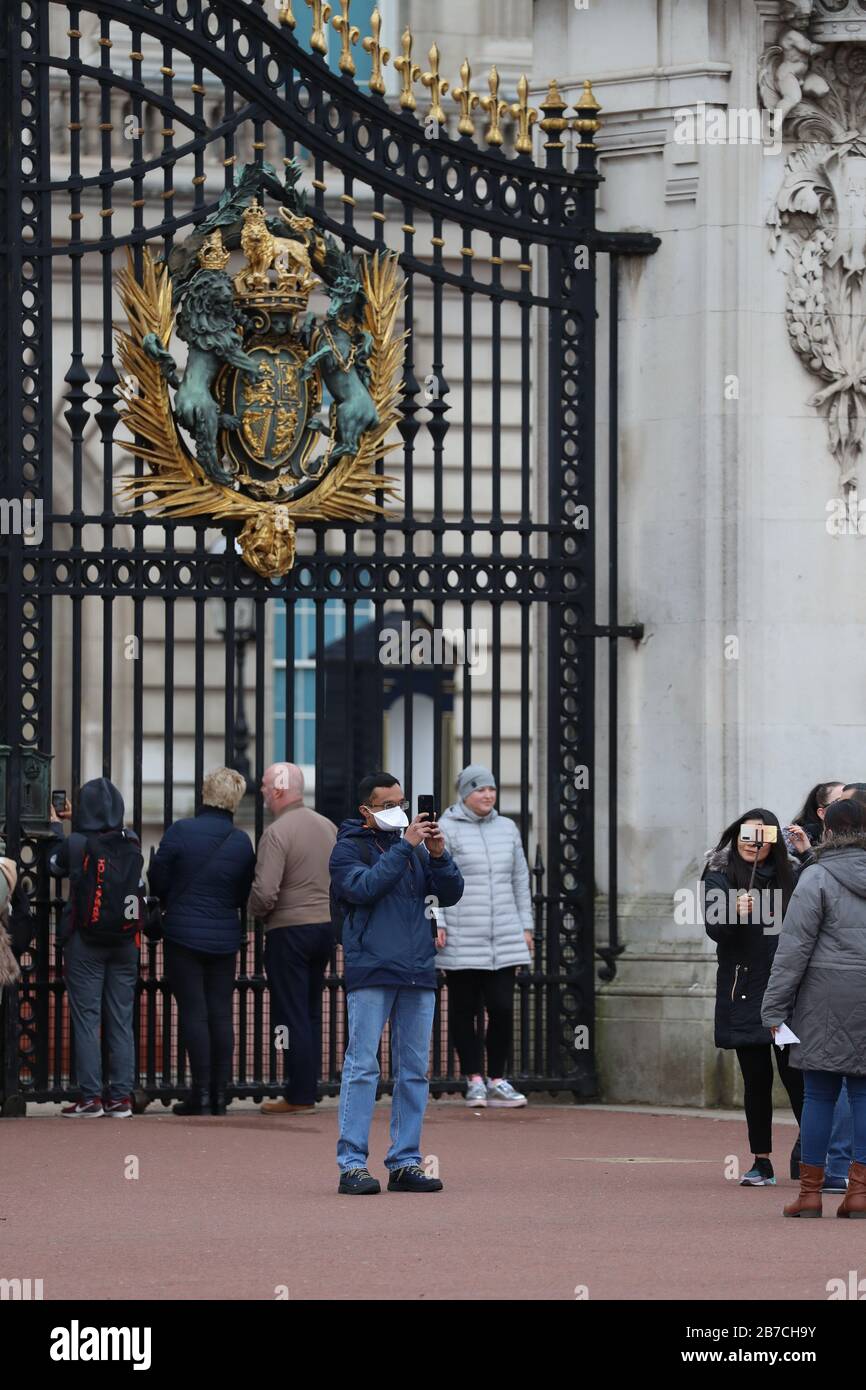 Un turista che indossa una maschera facciale per proteggersi dalla diffusione del coronavirus prende un selfie fuori da Buckingham Palace, Londra, come ha detto il segretario alla sanità Matt Hancock i ministri devono ancora decidere se vietare le riunioni di oltre 500 persone nel resto del Regno Unito, Dopo che la Scozia ha detto che avrebbe portato restrizioni a partire da lunedì. Foto Stock