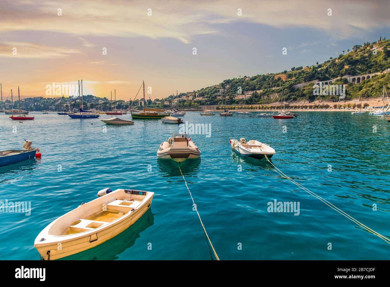 Piccole Barche Ormeggiate Nella Tranquilla Blue Bay Al Tramonto Foto Stock