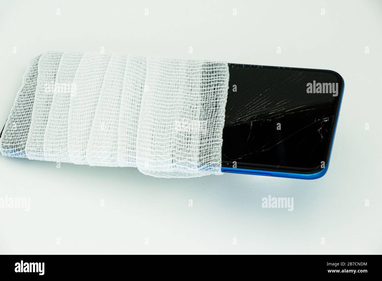 Concetto di smartphone rotto in bendaggio con sfondo bianco, crepe Foto Stock