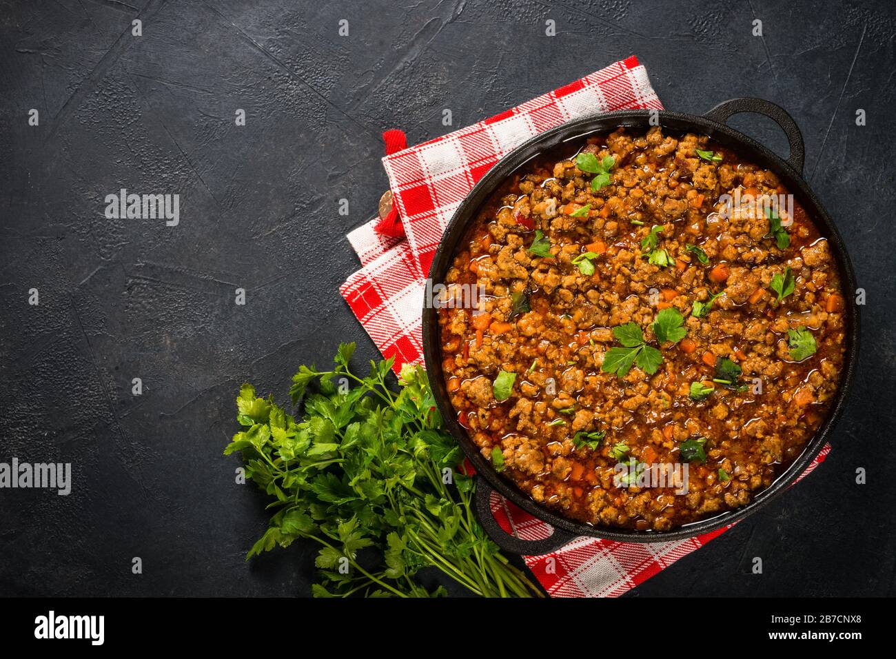 sause bolognese in piastra di ferro a tavola nera. Foto Stock