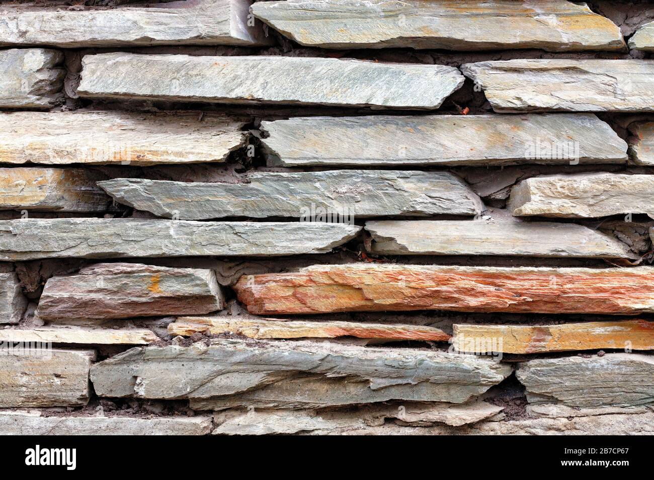 Particolare parte della vecchia pietra che trattiene il muro da pezzi di arenaria piatta. Foto Stock