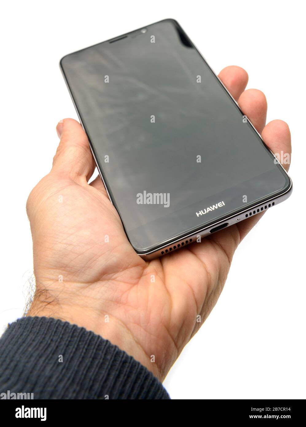 Mano che tiene lo smartphone Huawei Mate 9 tagliata su uno sfondo bianco Foto Stock