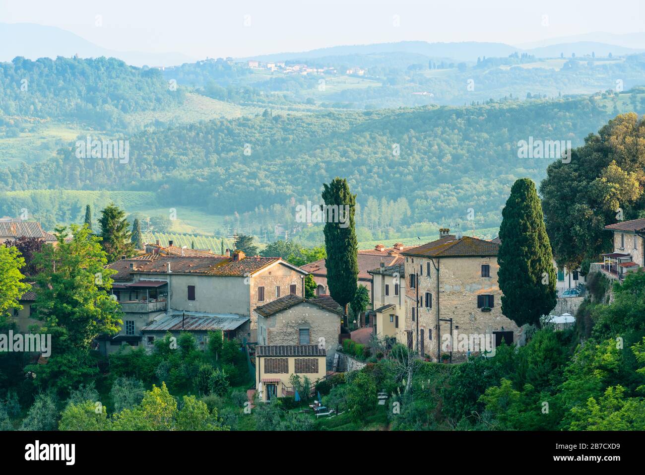 Edifici residenziali con una campagna toscana sullo sfondo a San Gimignano, provincia di Siena, Italia. Foto Stock