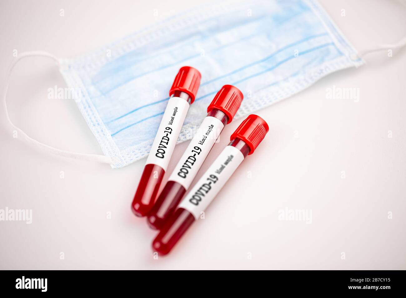 Campione di sangue per coronavirus e maschera protettiva. Foto Stock