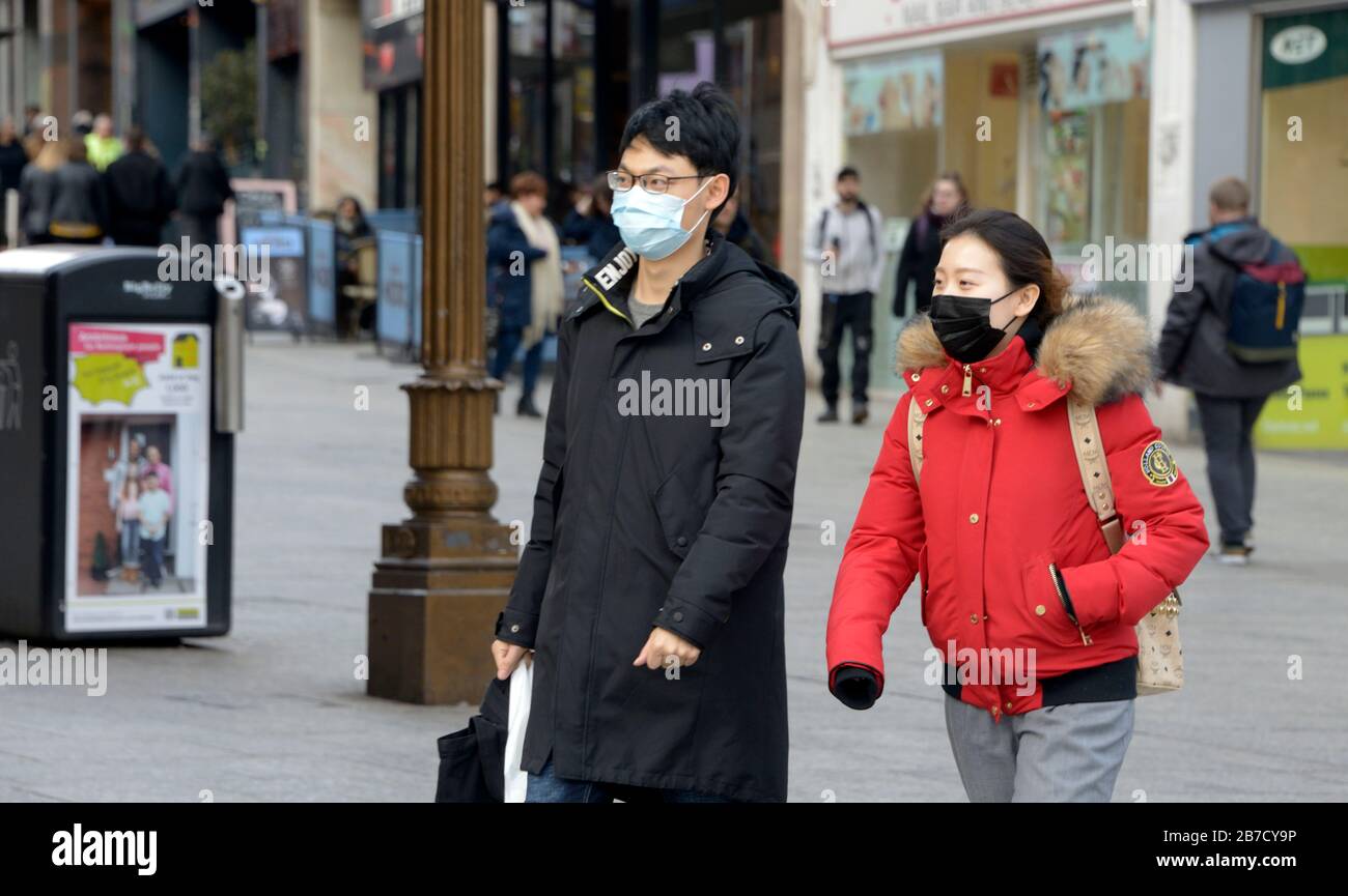 Giovane coppia cinese, in maschera facciale, in strada durante l'epidemia di Corona Virus. Foto Stock