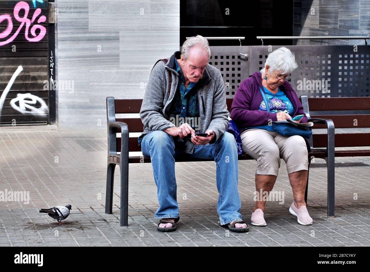 Due turisti americani sui loro telefoni cellulari nella Sagrada Familia, mentre la Spagna si prepara a chiudere il paese in mezzo alla pandemia Corovid-19. Foto Stock