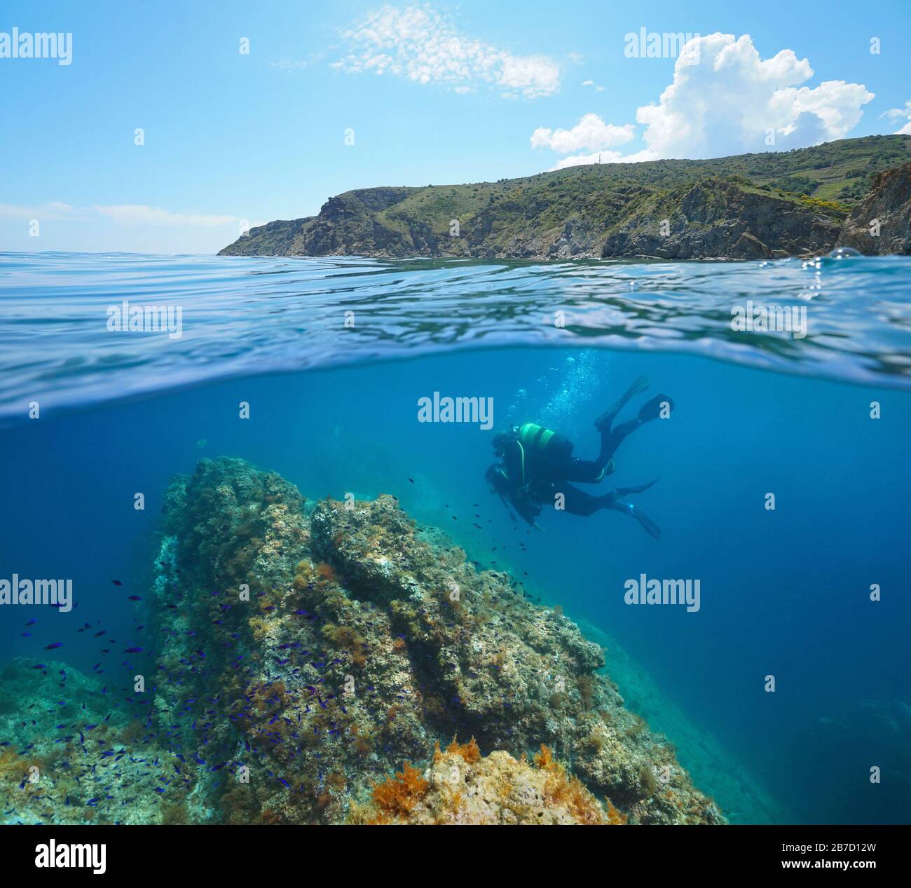 Immersioni subacquee in mare mediterraneo, due subacquei subacquei e la costa nella Riserva Marina di Cerbere Banyuls, vista su superficie sotto l'acqua, Francia Foto Stock