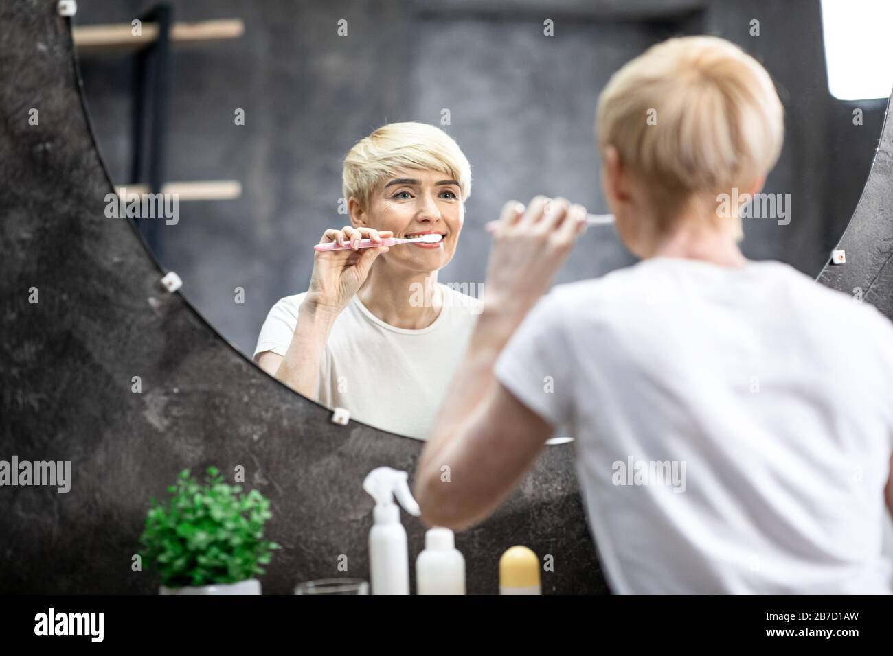 Happy Woman denti spazzolanti al mattino in piedi in bagno Foto Stock