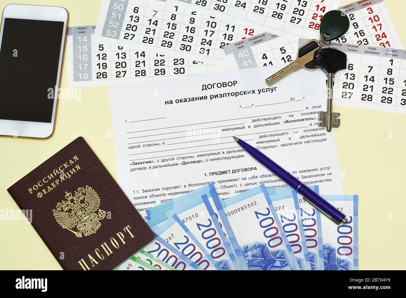 La forma del documento con il testo russo del Contratto per la prestazione di servizi immobiliari. Passaporto russo, smartphone, chiave e denaro Foto Stock