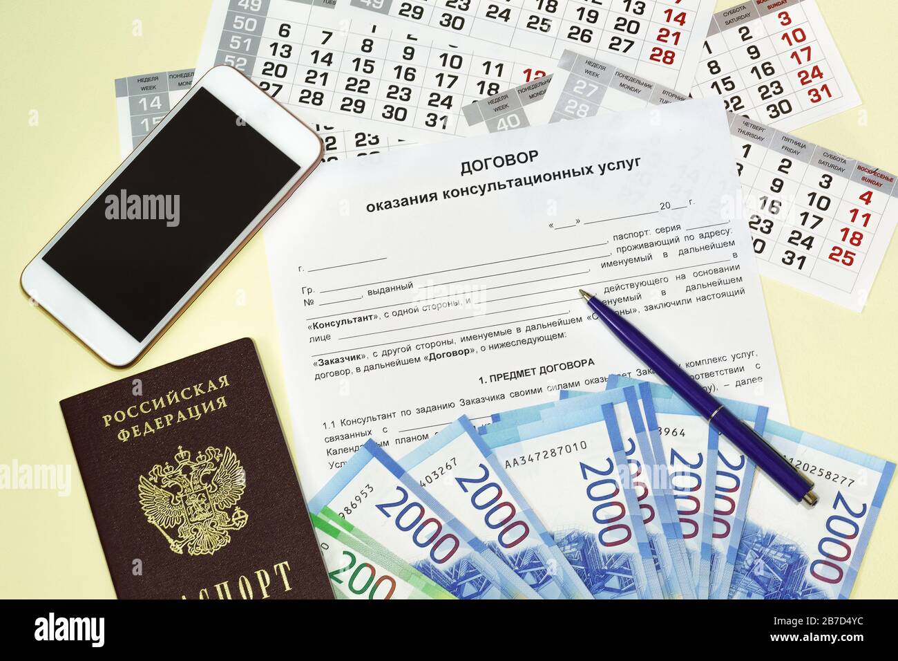 La forma del documento con il testo russo il contratto di prestazione di servizi di consulenza. Passaporto russo, smartphone e denaro sul tavolo. MU Foto Stock