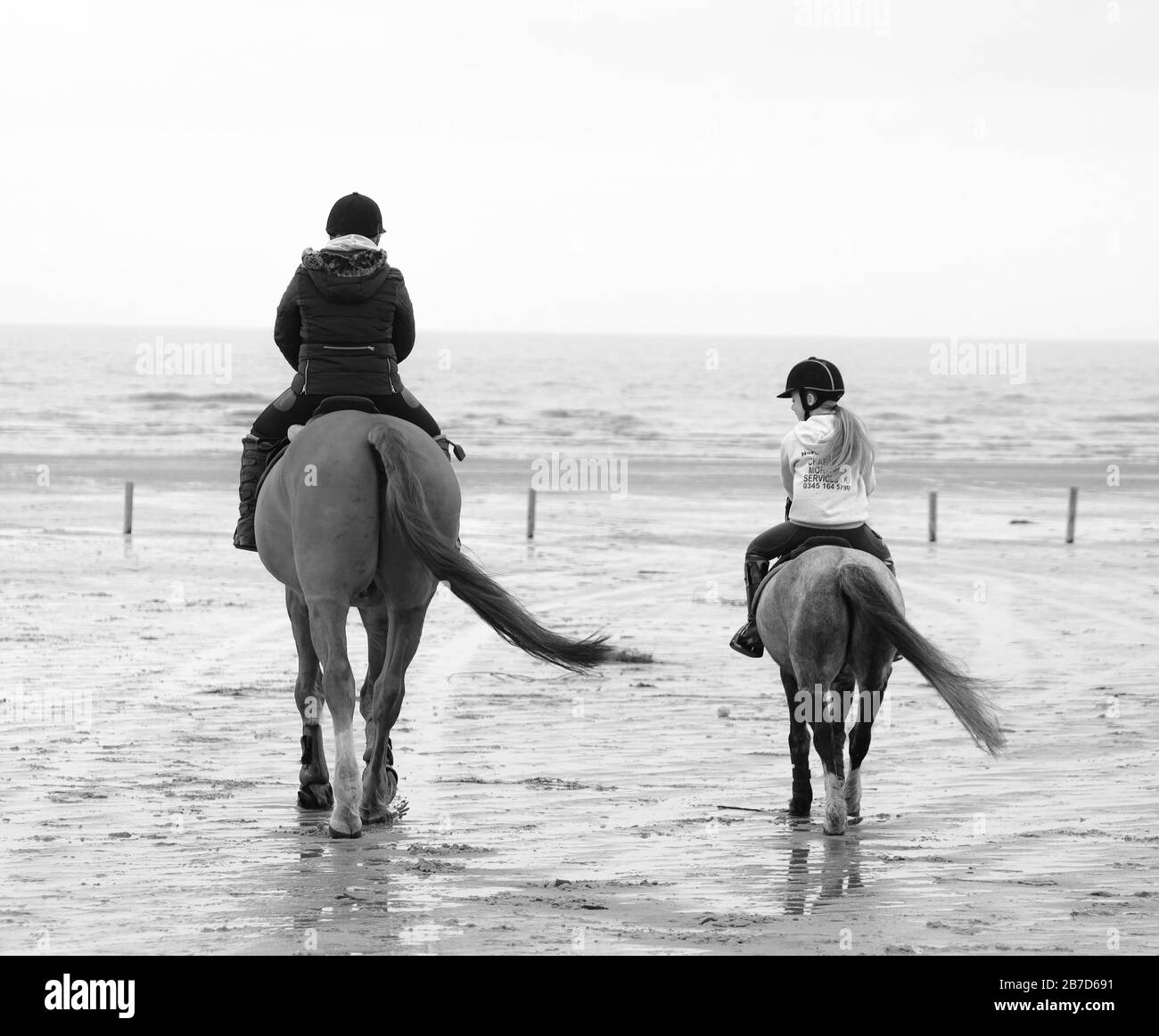 Una madre e una figlia camminano i loro cavalli sulla spiaggia di Ainsdale. Foto Stock