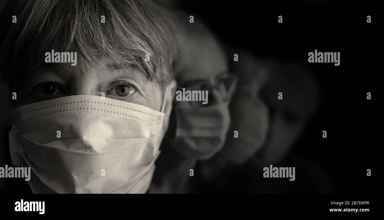 In primo piano indossa una maschera protettiva, nel secondo e terzo piano mascherato volti..pandemic. Foto Stock