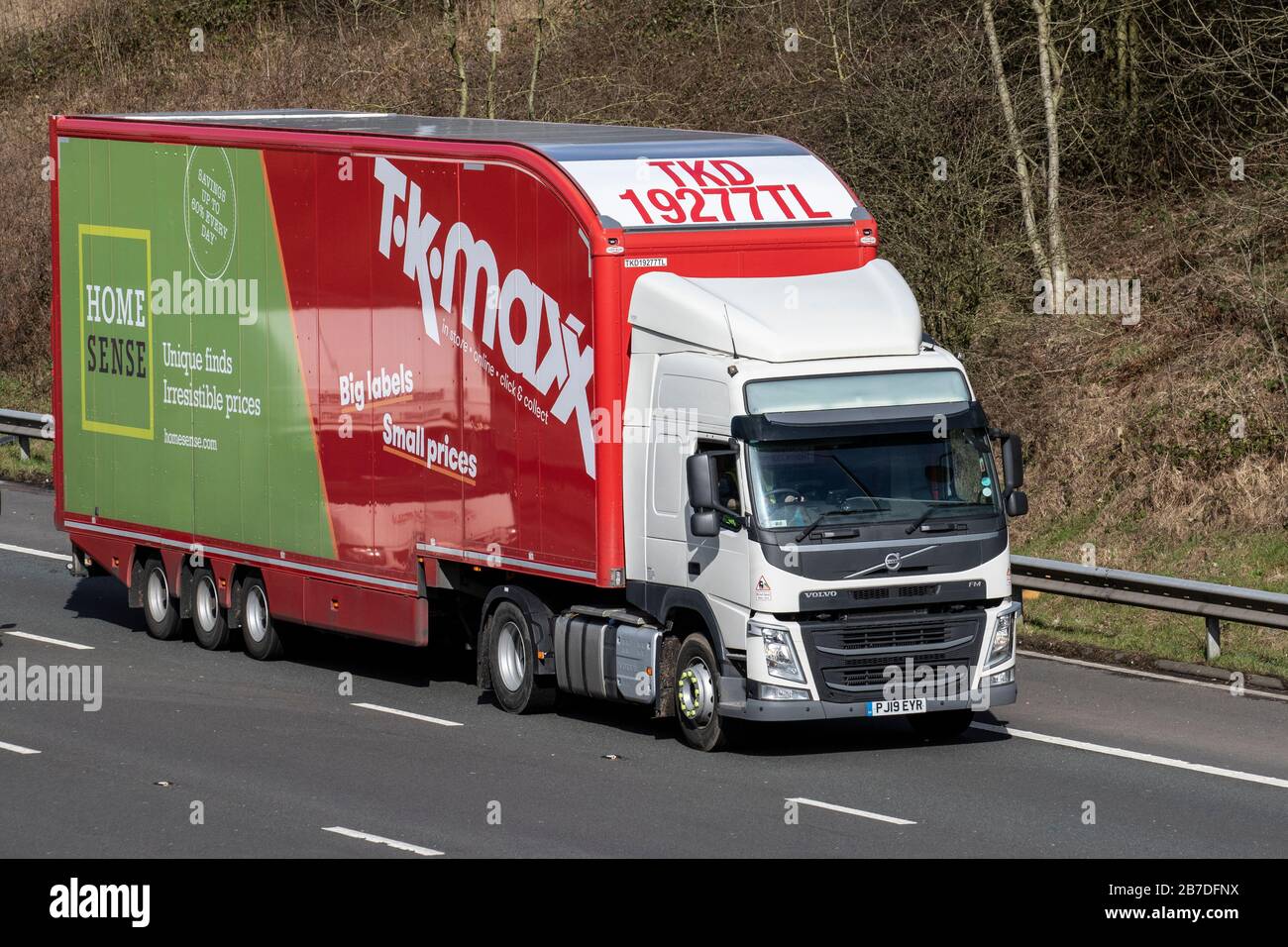 TK Maxx rosso bianco HGV consegna camion, camion, trasporto, camion, cargo, Volvo veicolo, industria europea del trasporto commerciale, M61 a Manchester, Regno Unito Foto Stock