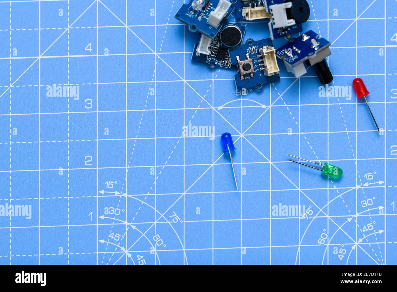 Circuiti stampati e componenti elettrici a LED blu, gree e rossi su sfondo blu. Concetto di elettronica, scienza, industria, hobby o istruzione. Foto Stock