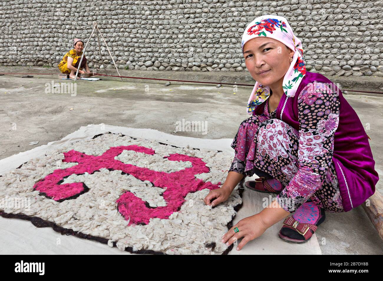 Donna uzbeka in costume locale facendo sentire, a Rishtan, Uzbekistan. Foto Stock