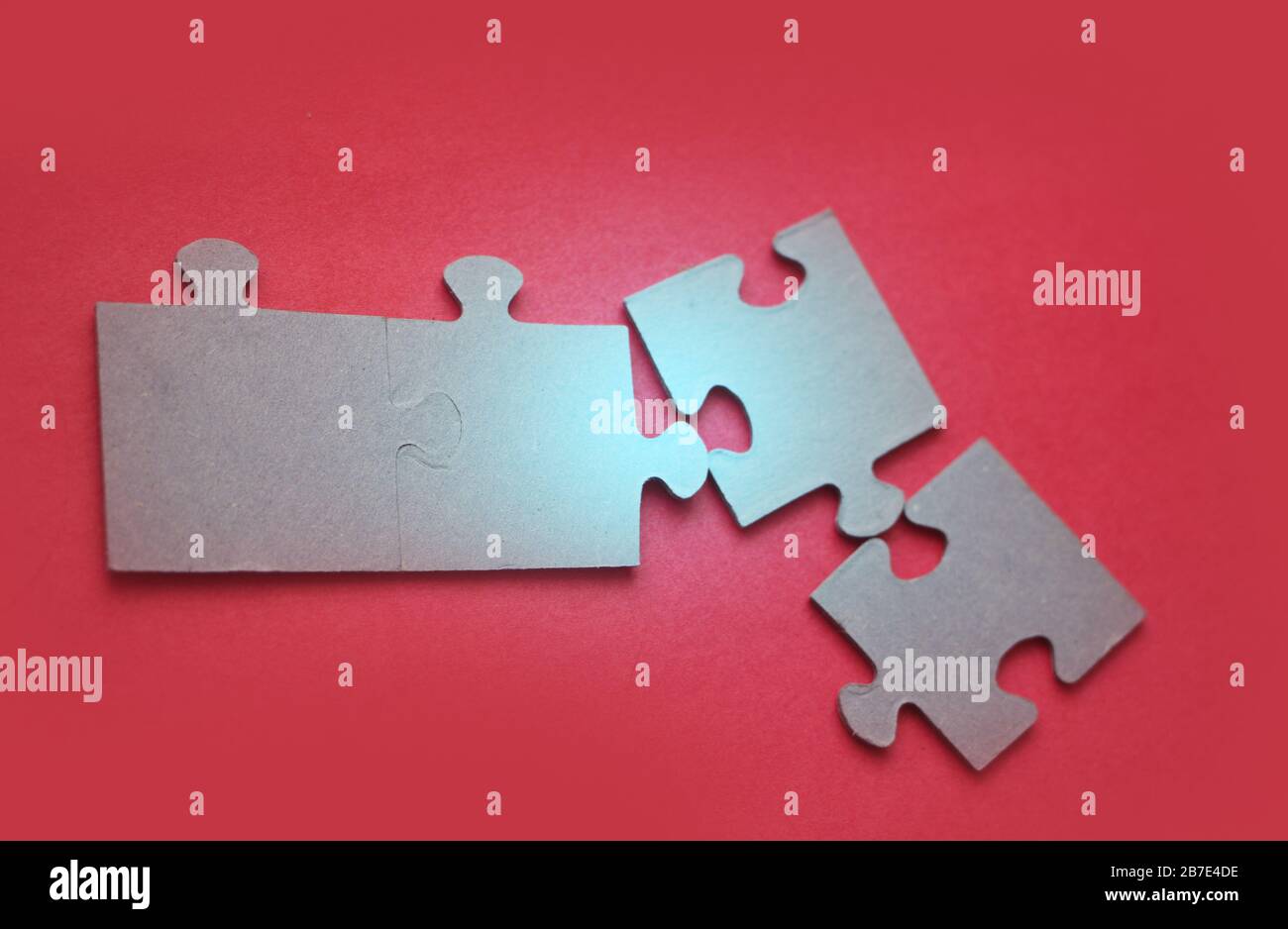 Luce brillante su puzzle su sfondo rosso, primo piano Foto Stock