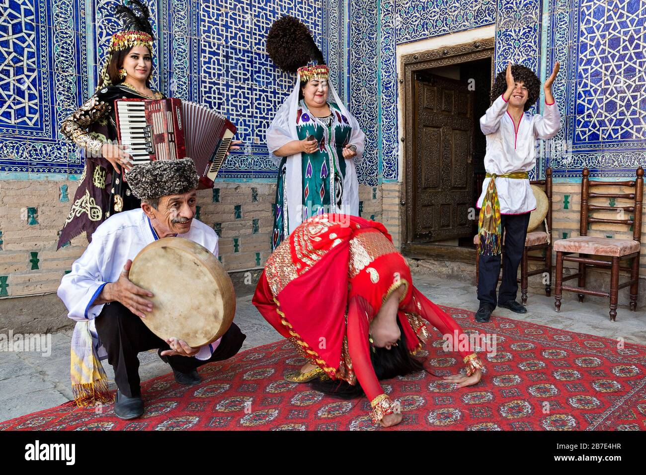 Musicisti Khorezmiani in abito locale che suonano musica e danza locale, a Khiva, Uzbekistan Foto Stock