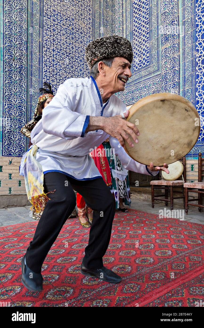 Il musicano Khorezmiano suona lo strumento musicale locale del tamburello, a Khiva, Uzbekistan Foto Stock