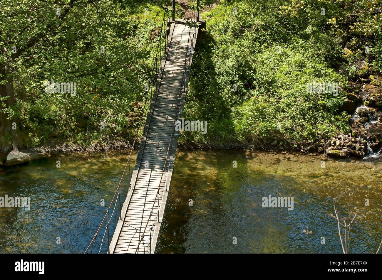 Vecchio ponte sospeso sul fiume Vit in primavera vicino alla città di Teteven, Bulgaria Foto Stock