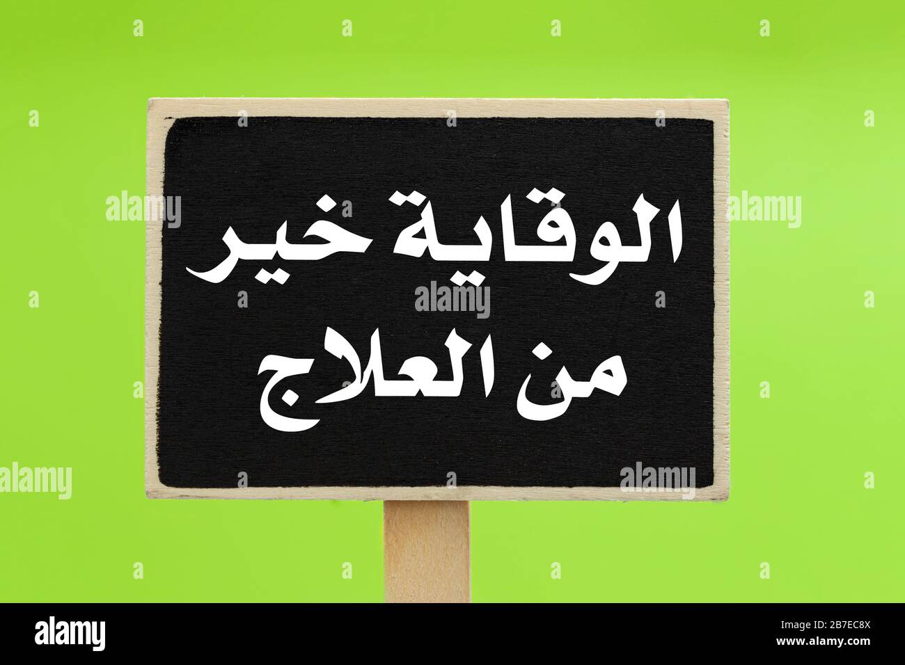 La prevenzione è migliore di Cure scritto in arabo (الوقاية خير من العلاج) su una lavagna su sfondo verde Foto Stock