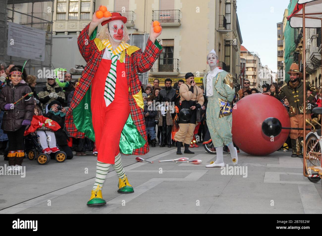 Sfilata di carnevale colorata in fondo alla strada con clown. Foto Stock
