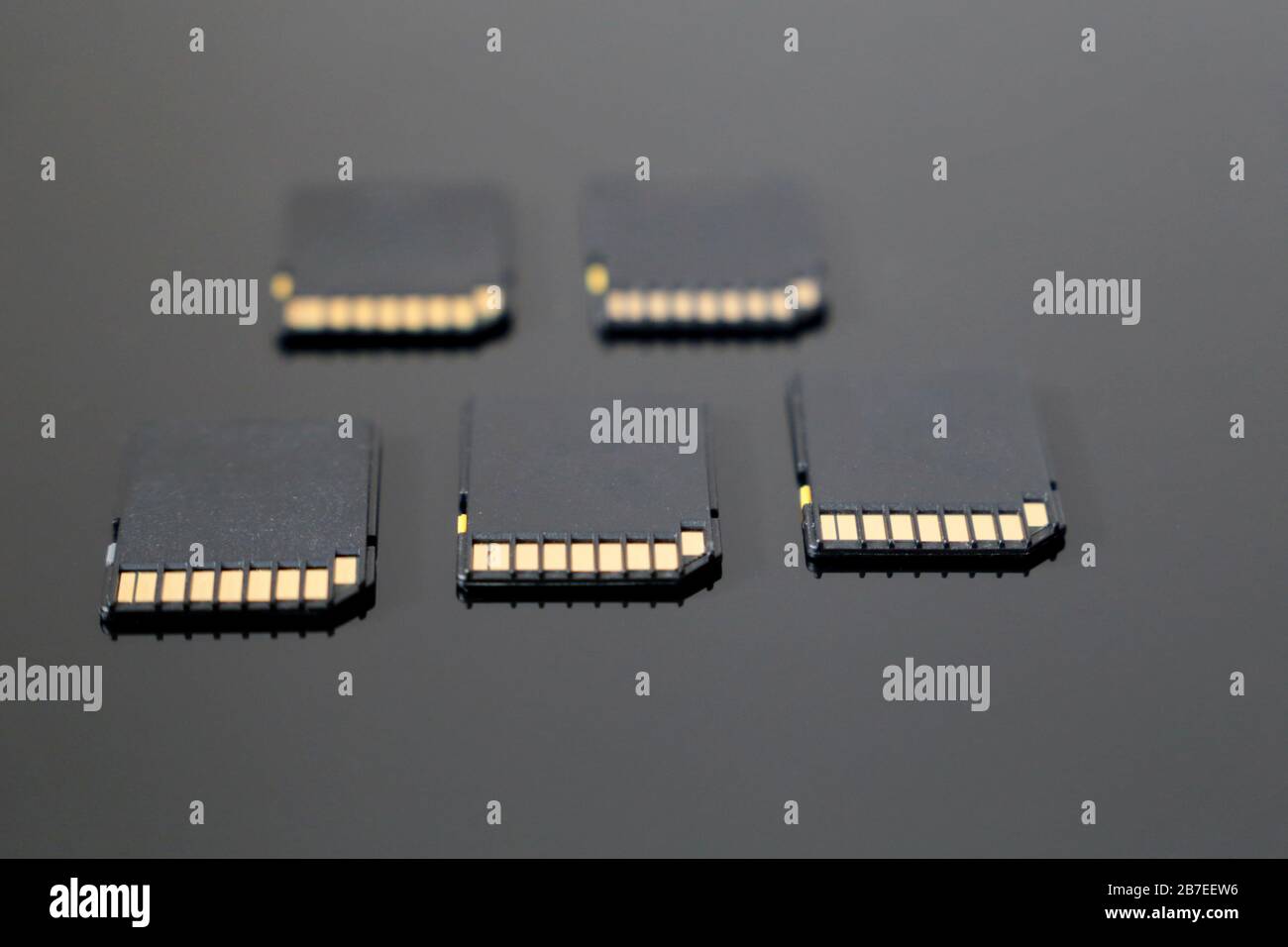 Schede di memoria SD su superficie in vetro nero, messa a fuoco selettiva. Concetto di archiviazione dei dati Foto Stock