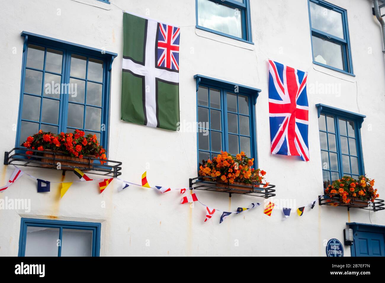 Bandiera Union Jack appesa su edificio bianco, Dartmouth, Devon, Inghilterra Foto Stock