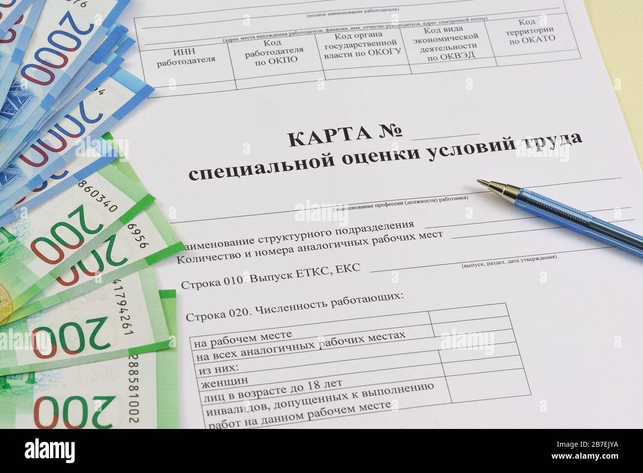 Modulo in russo: "punto di valutazione speciale delle condizioni di lavoro", penna a sfera e la nuova banconota russa da duemila rubli sul tavolo. S Foto Stock