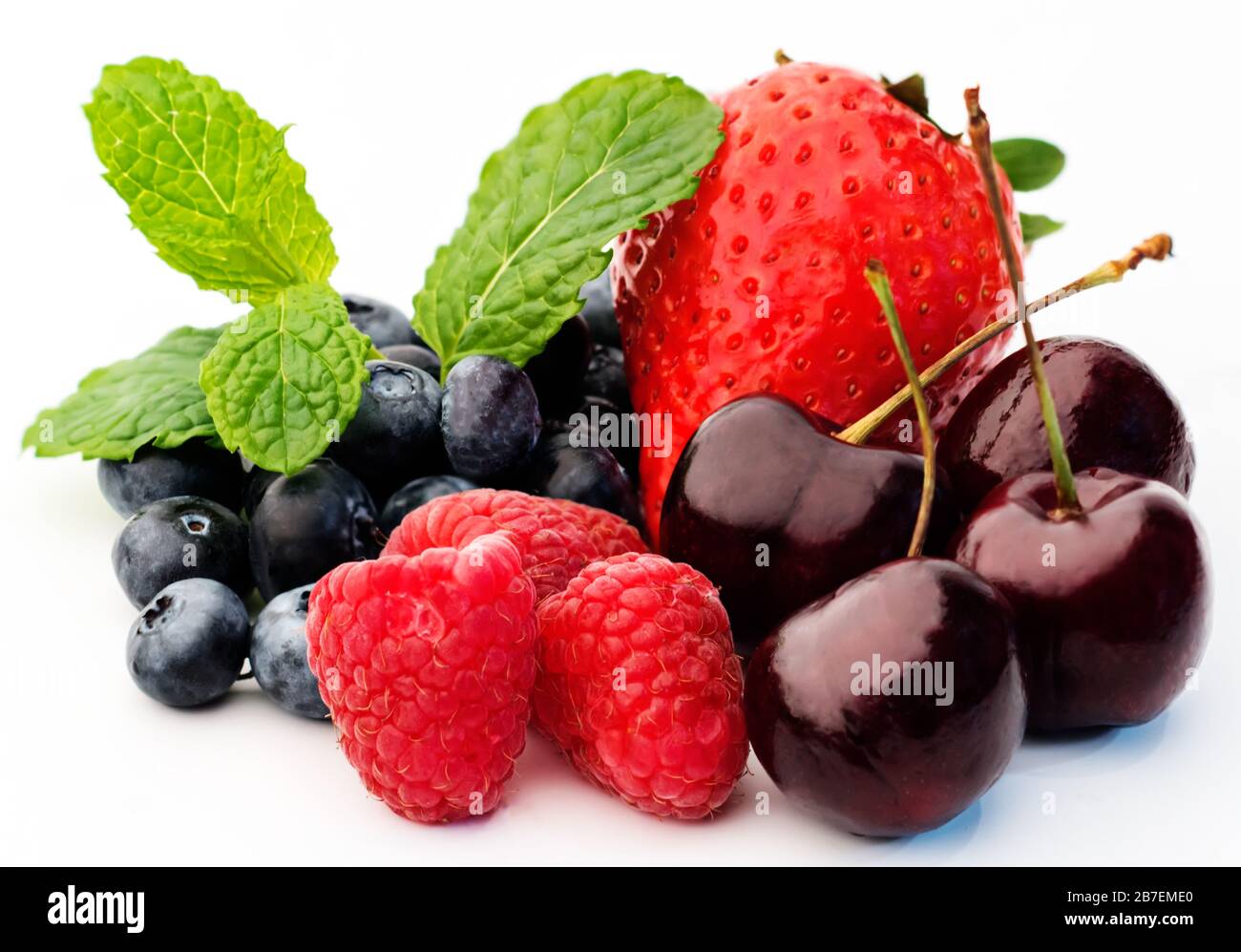 Diverse bacche estive fresche (lampone, ciliegia, mora, fragola) isolate su sfondo bianco. Foto Stock