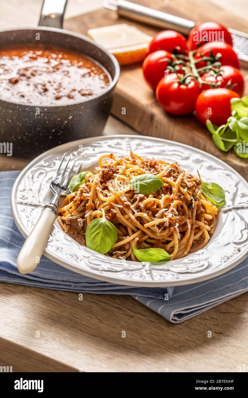 Pasta italiana spaghetti bolognese serviti su piatto bianco con parmigiano e basilico Foto Stock