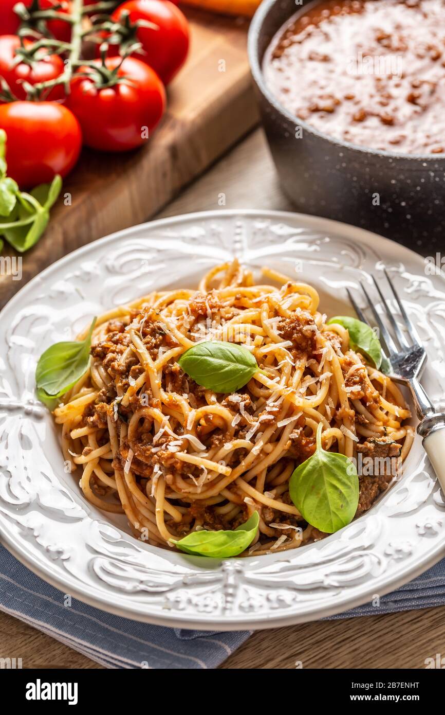 Pasta italiana spaghetti bolognese serviti su piatto bianco con parmigiano e basilico Foto Stock
