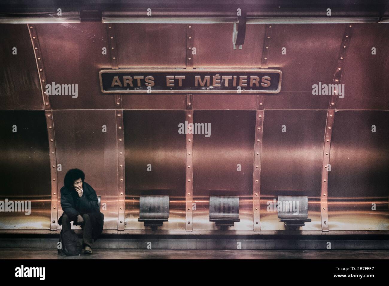 Un uomo sfida le regole e fuma una sigaretta alla stazione della metropolitana Arts et Metiers, Right Bank, Parigi, Francia, Europa, colore Foto Stock