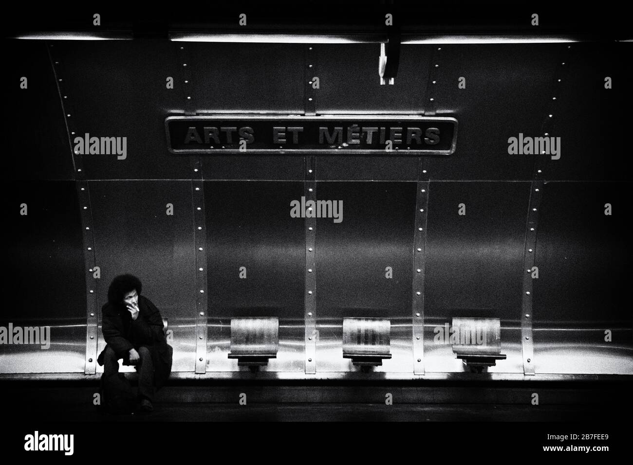 Un uomo sfida le regole e fuma una sigaretta alla stazione della metropolitana Arts et Metiers, Right Bank, Parigi, Francia, Europa, bianco e nero Foto Stock