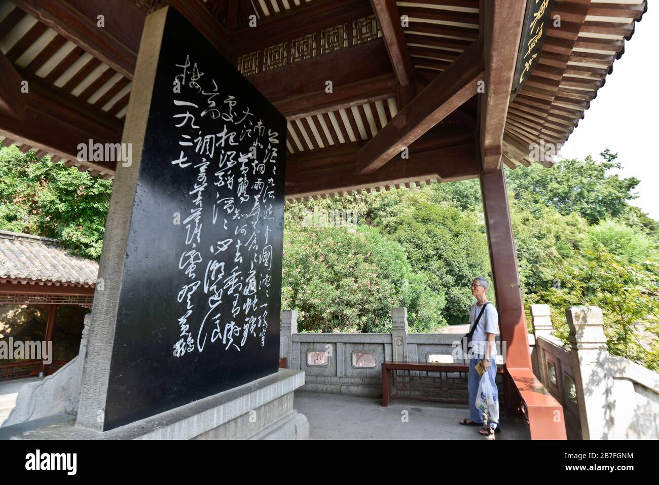Parco della Torre della Crane gialla: Padiglione di Stele di Mao Zedong ci - poesie, con un vecchio uomo che legge. Wuhan, Cina Foto Stock