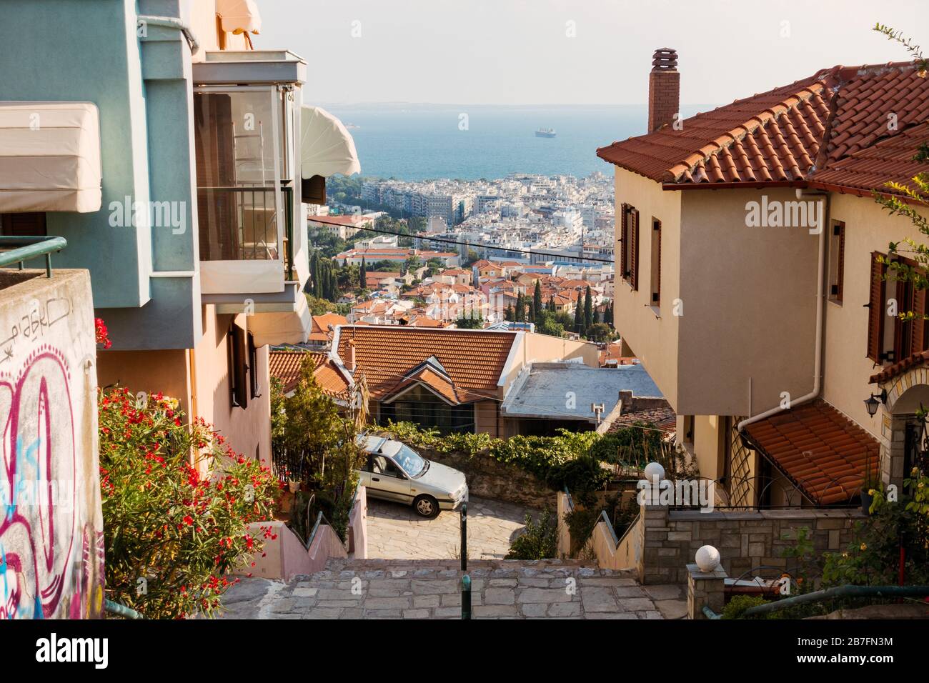 Affacciato sul mare del Golfo Termaico da un'elevata periferia residenziale di Salonicco, Grecia. Un muro sulla sinistra è visto graffiato Foto Stock