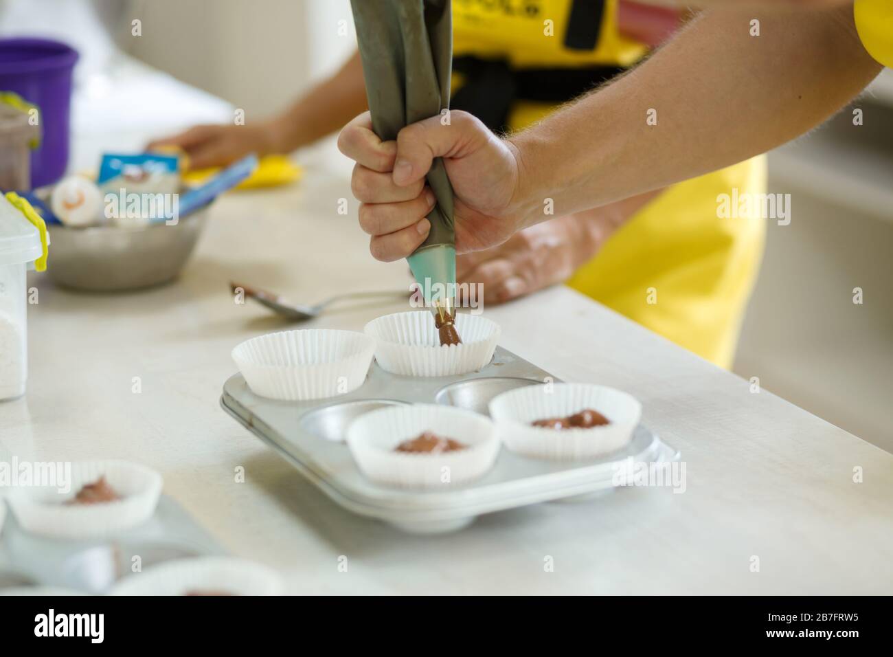 Donna chef professionista pasta spalmare pasta di cioccolato in piatto da forno. Foto Stock