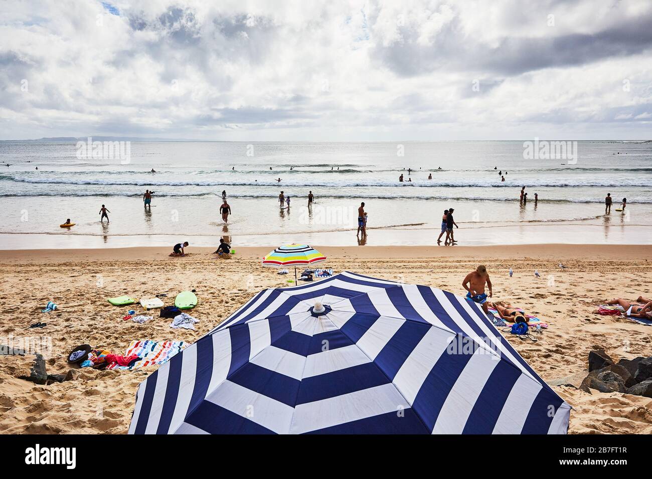 Folla di persone che godono di prendere il sole, surf e la vita a Noosa Main Beach, Queensland, Australia Foto Stock