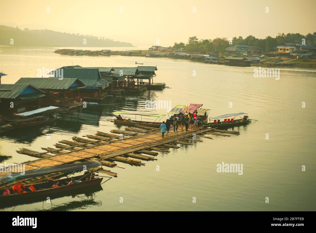 Turisti in attesa di una barca a Sam Pra Sob nel distretto di Sangkhla Buri, provincia di Kanchanaburi, Thailandia. Foto Stock