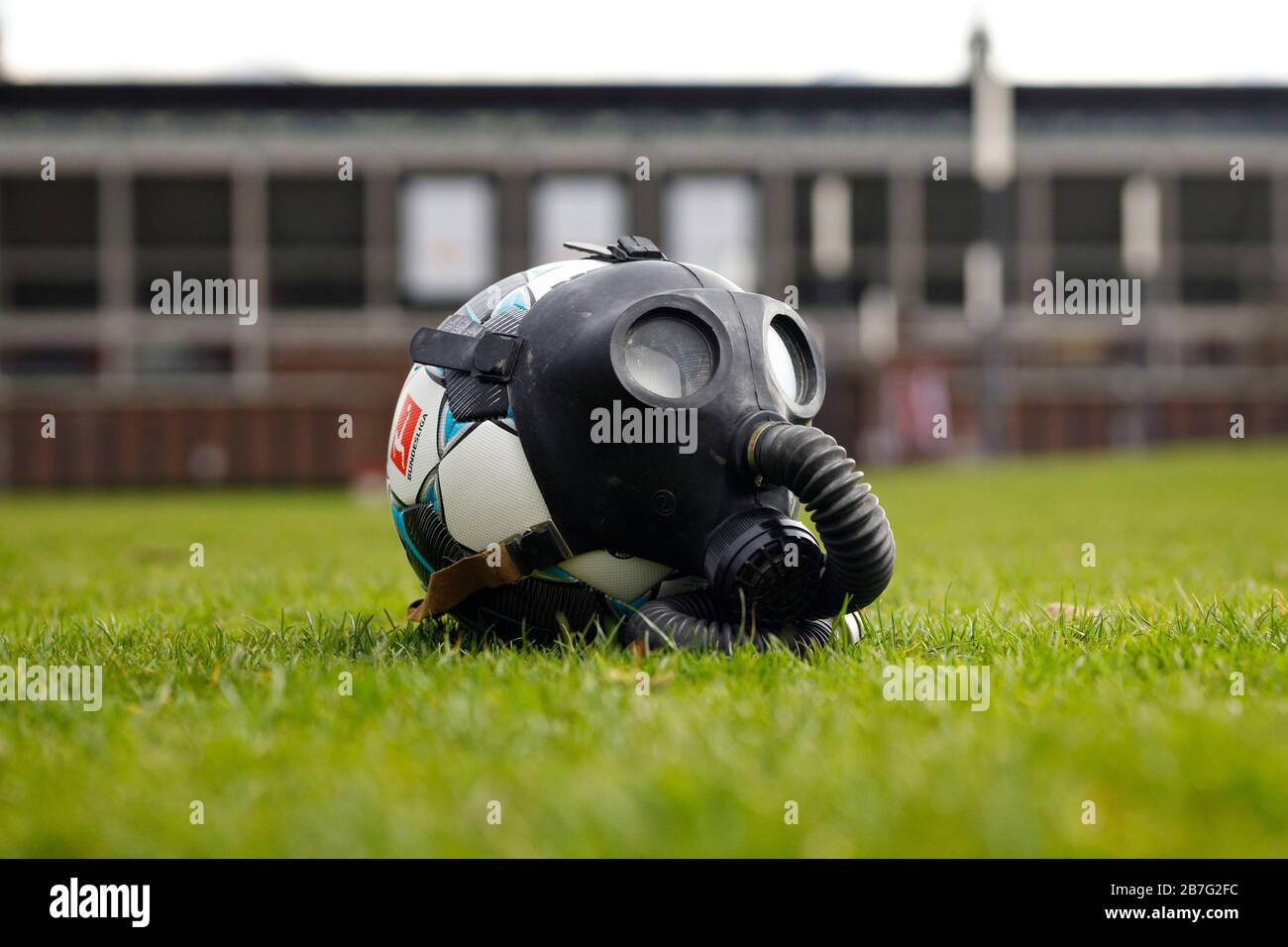 Colonia, Germania. 14 Marzo 2020. Un pallone da calcio con una maschera a gas di fronte allo stadio RheinEnergie. Koln, 14 marzo 2020 | utilizzo in tutto il mondo Credit: dpa/Alamy Live News Foto Stock