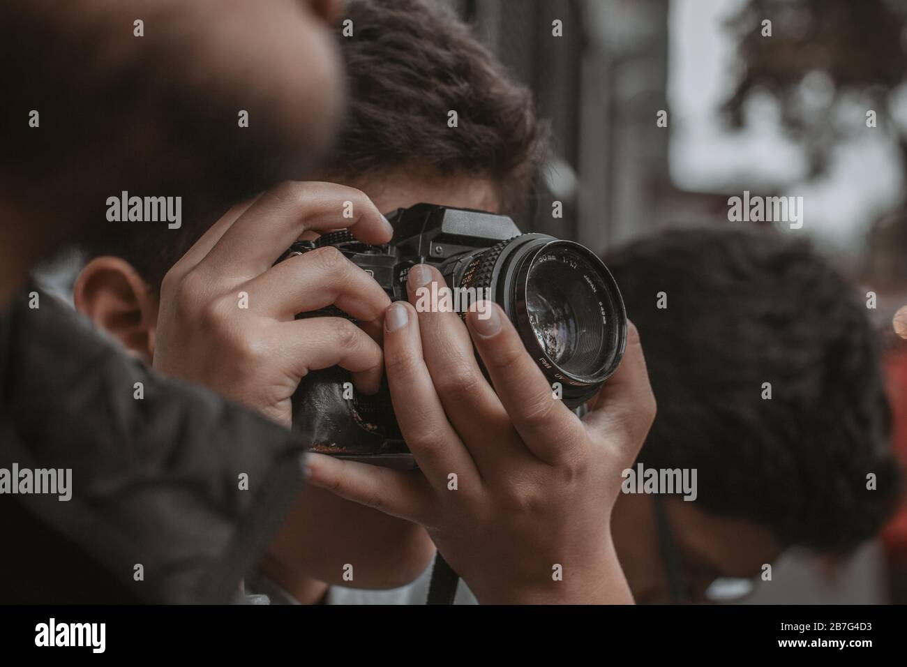 Primo piano di un uomo in una folla che scatta foto Foto Stock