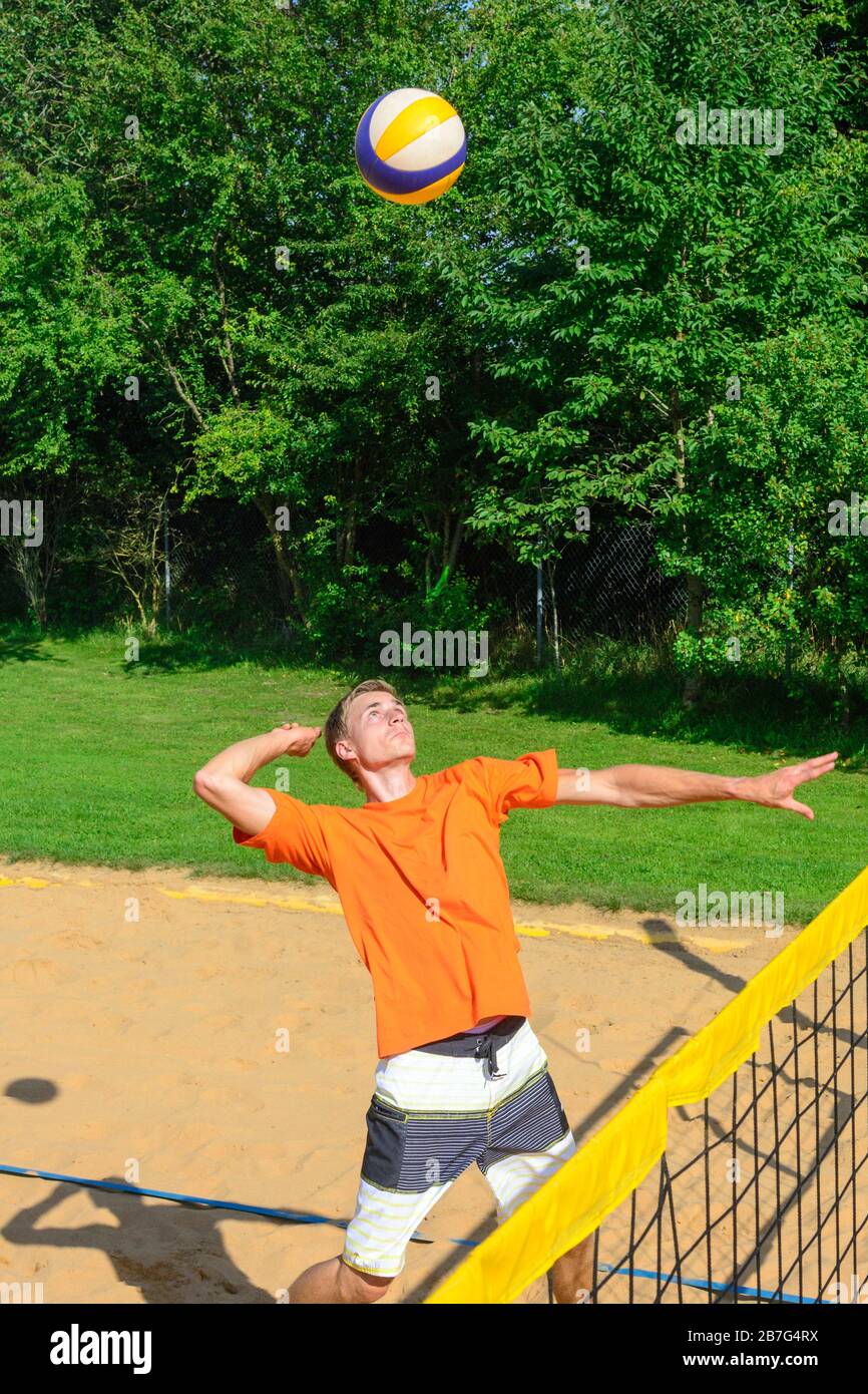 Gioco intensivo sul campo di beachvolley, uomo che fa un smash Foto Stock