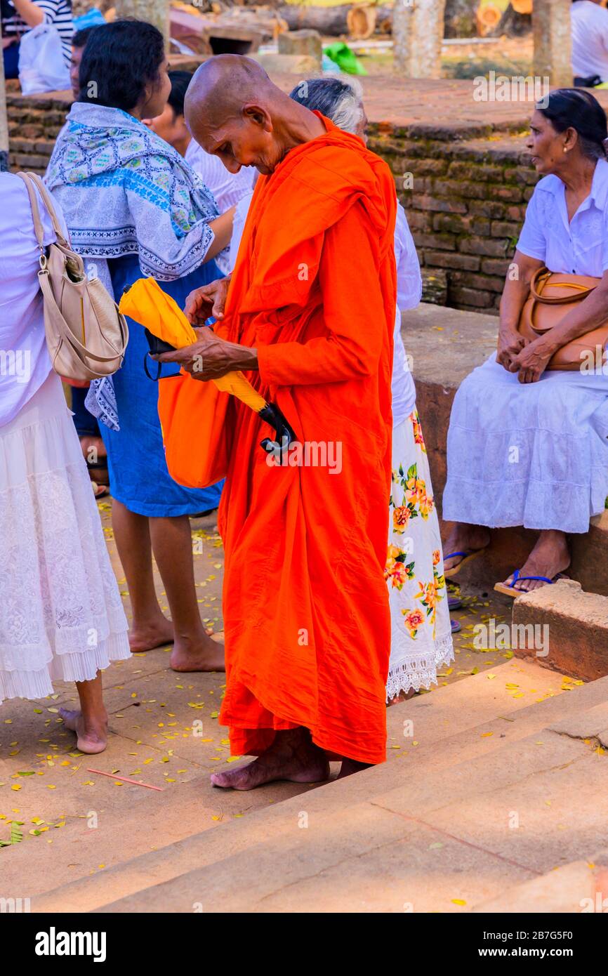 Sri Lanka Ceylon Triangolo Culturale Anuradhapura Mahaseya Dagoba stupe pagoda complesso buddista monaco rosso arancio abiti Foto Stock
