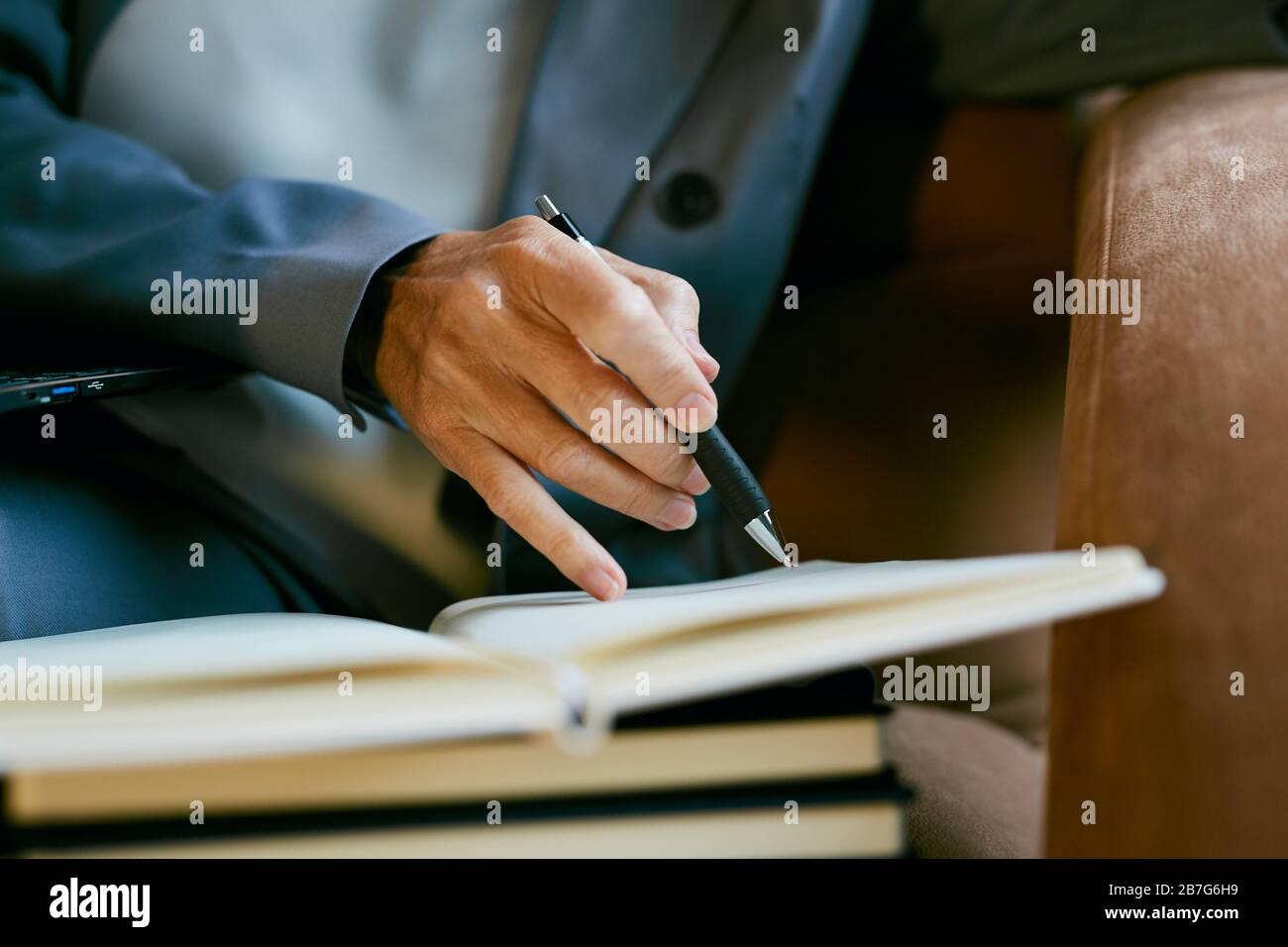 Primo piano di maturo riuscito businesswoman tenendo la penna mentre prendendo le note nel pianificatore, spazio di copia Foto Stock