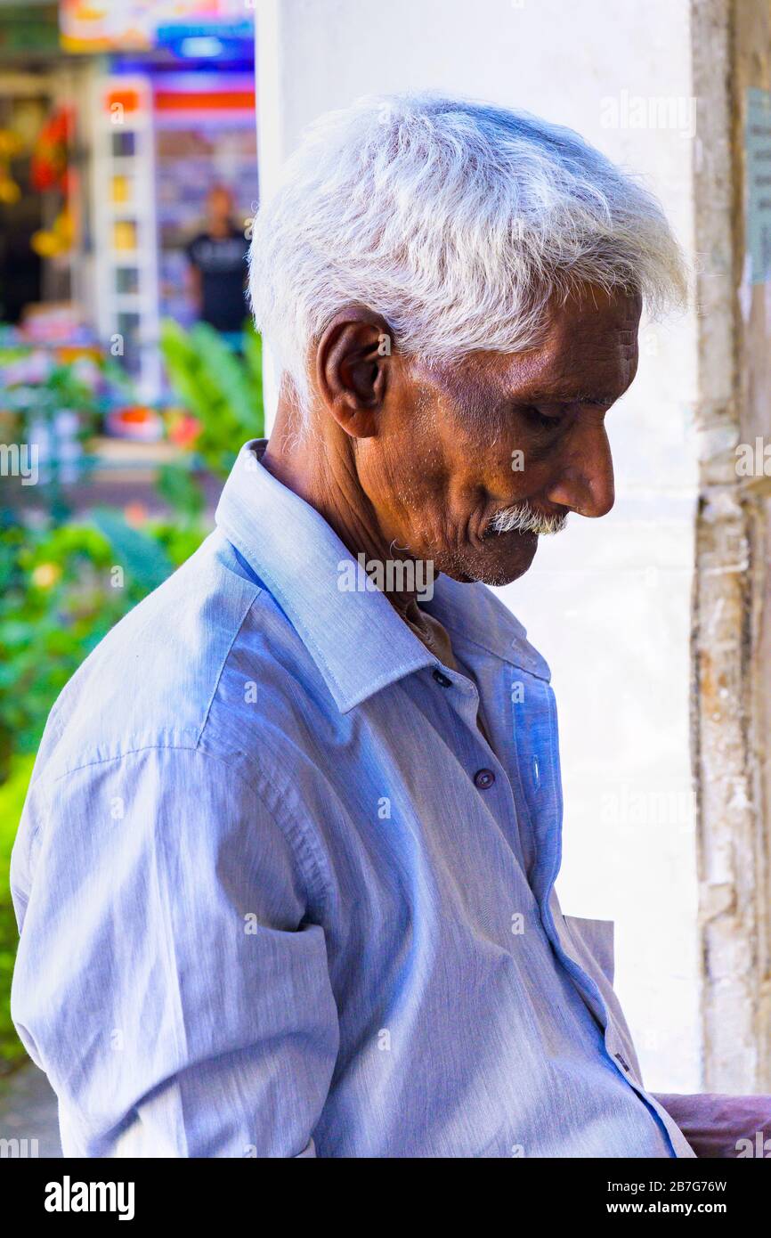 Asia meridionale Sri Lanka Kandy Swinala Provincia Centrale antica capitale anziani uomo grigio capelli baffi stoppia venditore strada distinto camicia blu Foto Stock