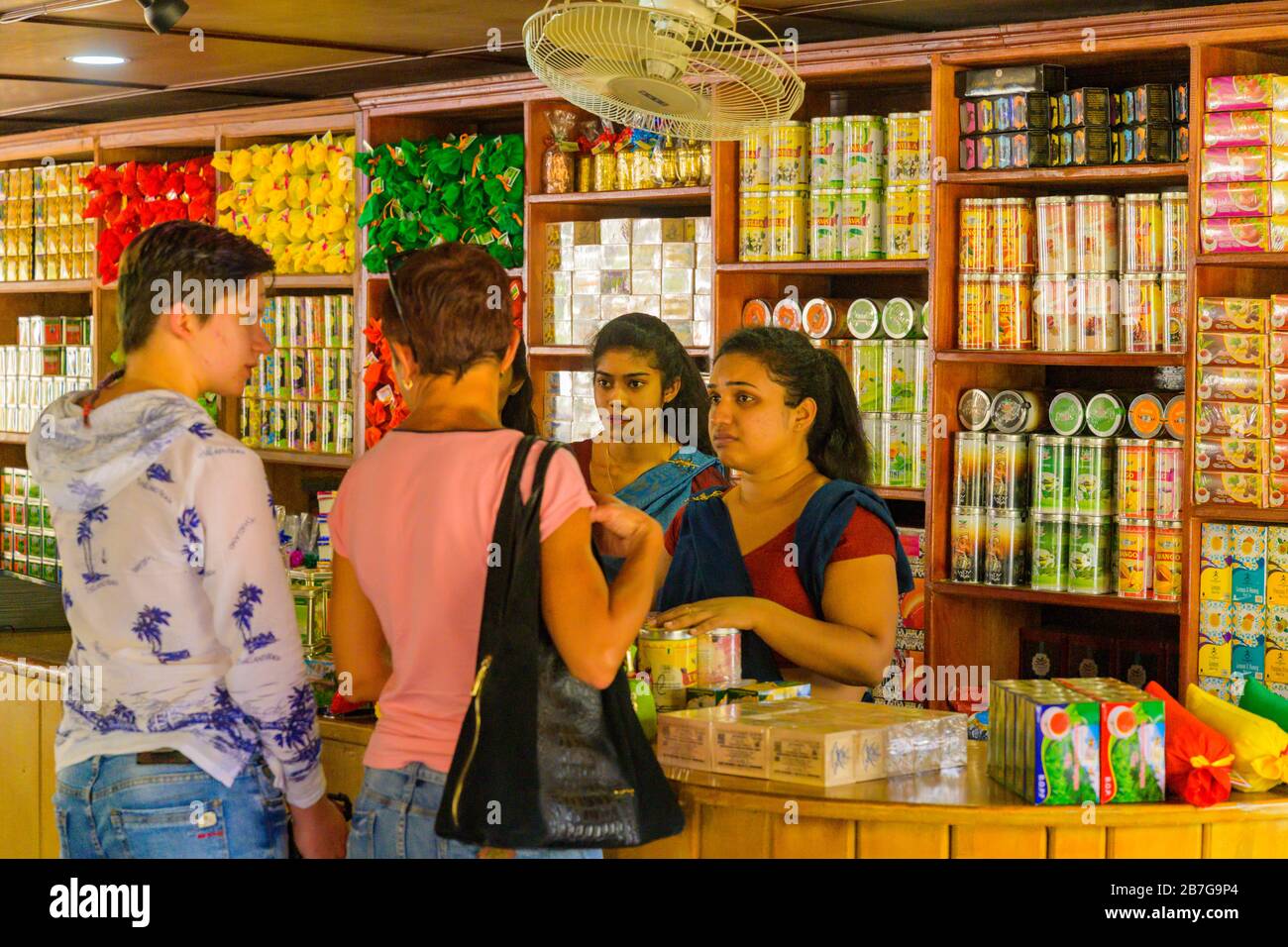 Sud Asia Sri Lanka Geragama Estate Tea Factory negozio piuttosto Signore in saris vendere varietà di tè scaffali clienti bancone Tins pacchetti Foto Stock