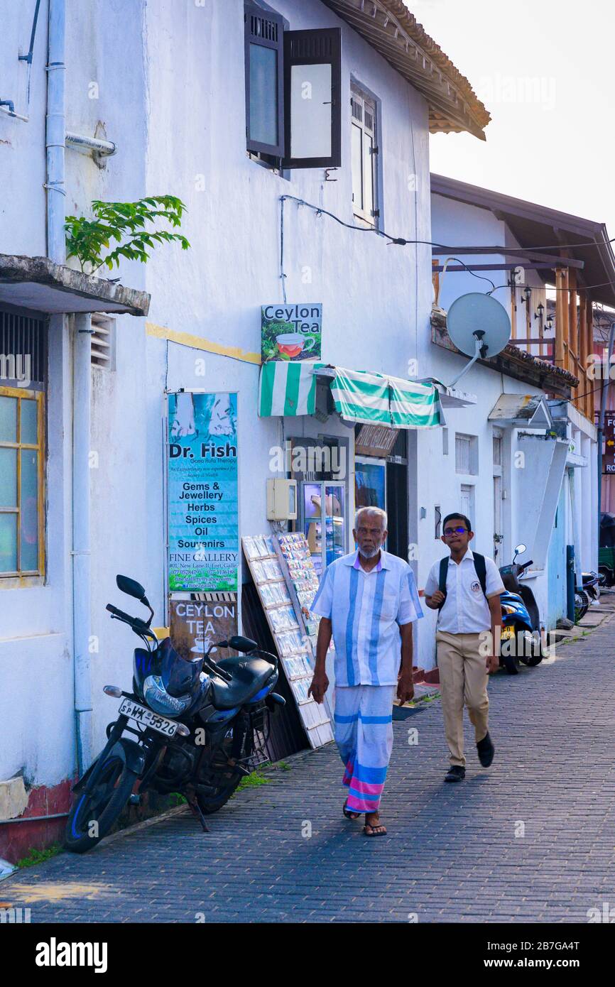 Sud Asia Sri Lanka Fort Galle backstreet scena open drain balcone case coloniali negozi negozi moto biciclette Dr Fish Garra Rufa Therapy Foto Stock