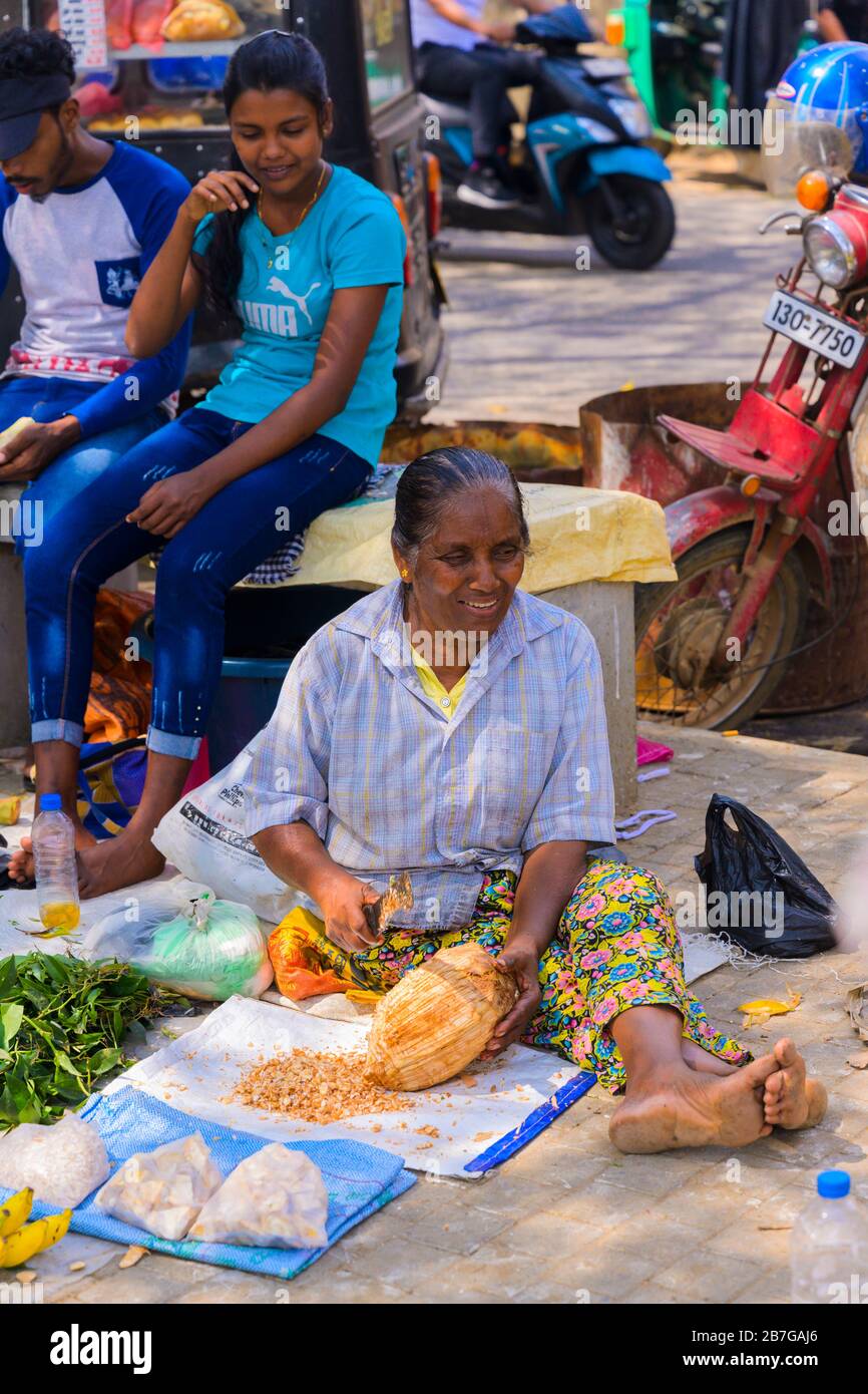 Sud Asia Sri Lanka Fort Galle centro città coloniale vecchio porto antico fornitore apertura jackfruit seduta marciapiede scena machete strada Foto Stock