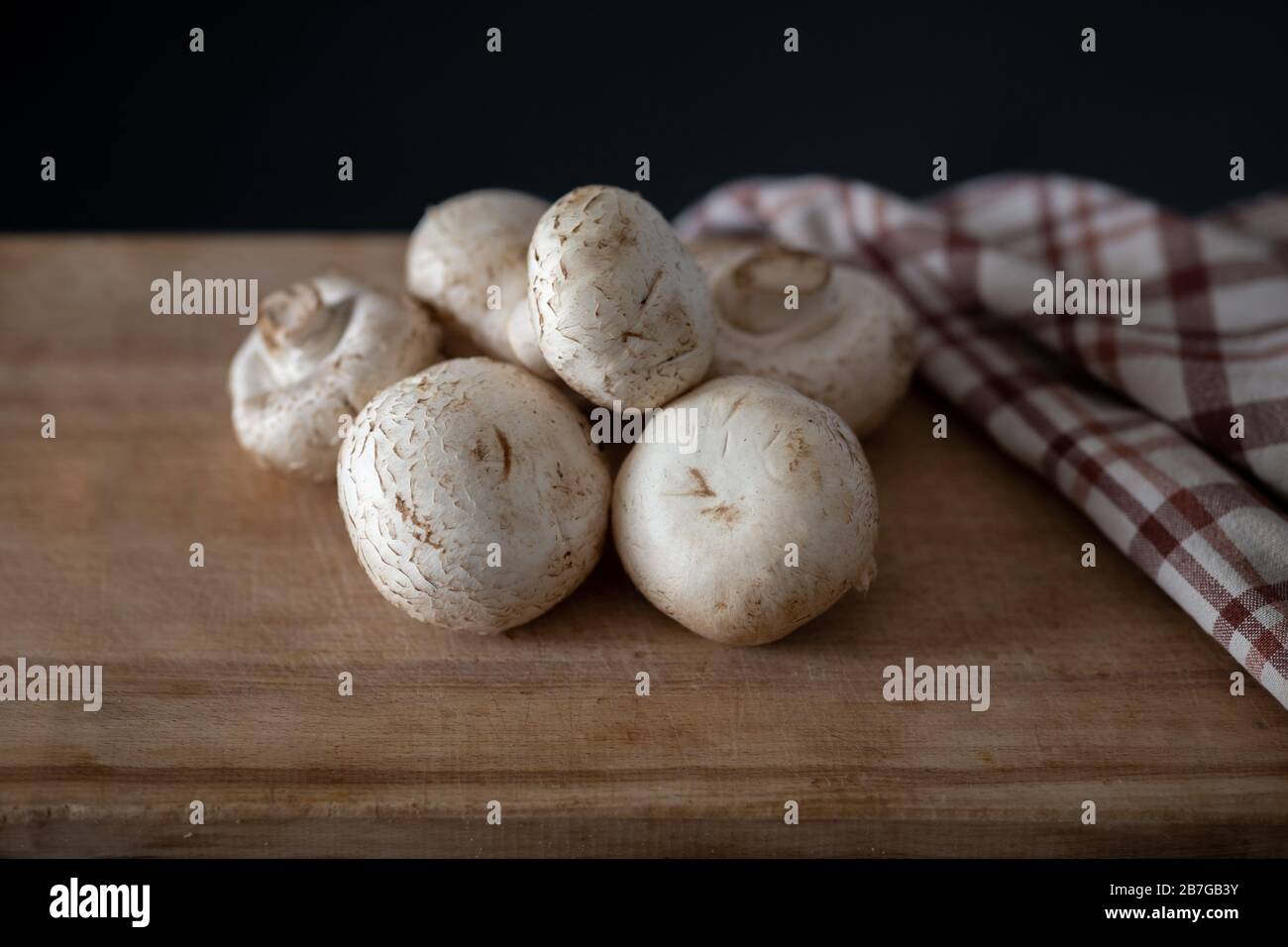 diversi champignons freschi che posano su tagliere di legno Foto Stock